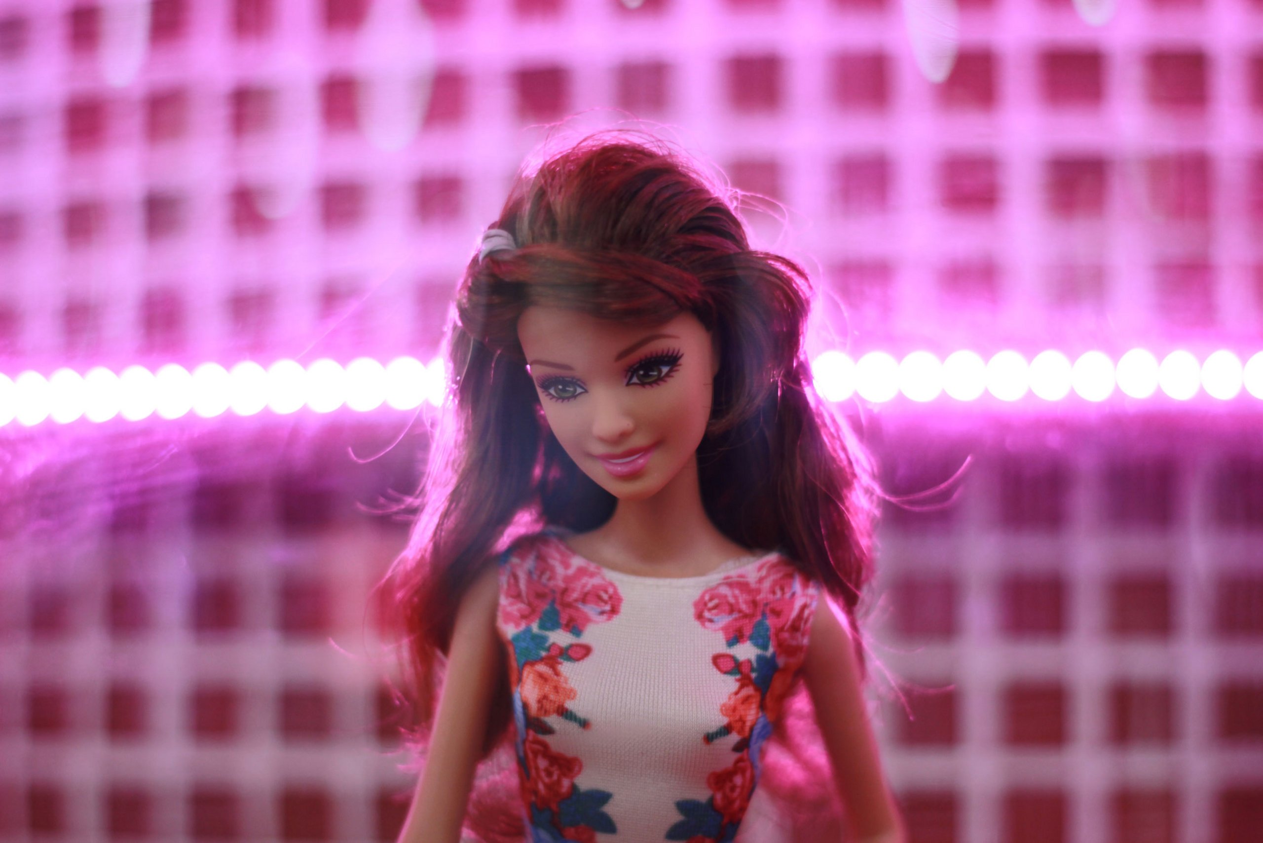 Barbie Puppe mit braunen Haaren vor rosa Hintergrund