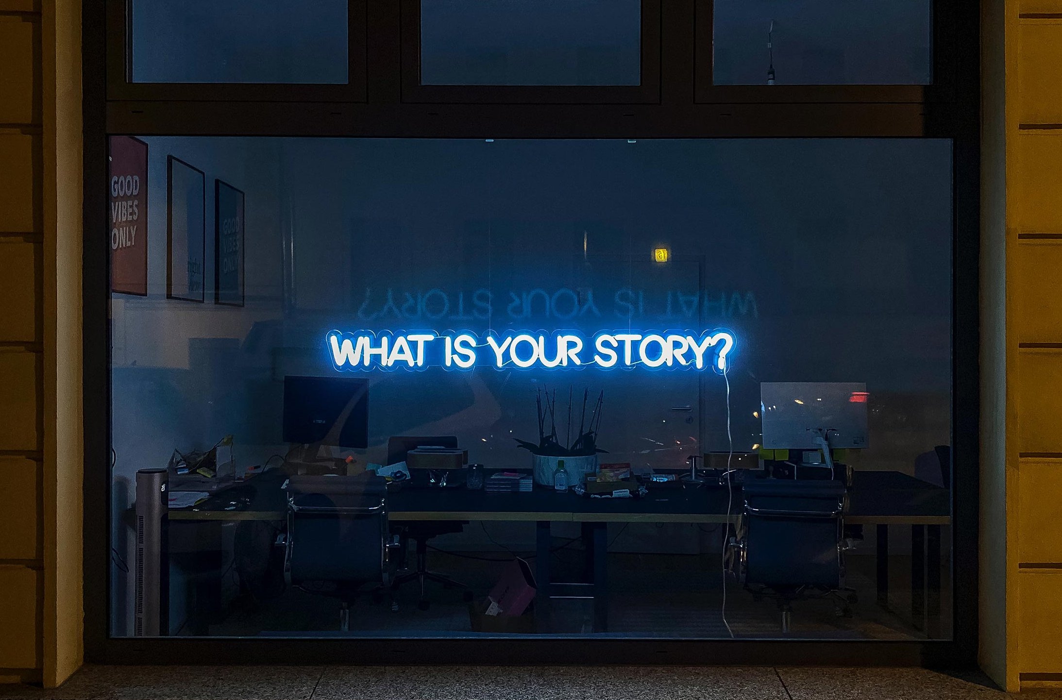 Schaufenster mit Leuchtschrift "What is your story?"